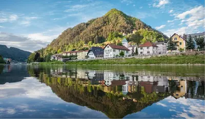 a town on the river with a mountain in the background at Apartments Artorius Laško in Laško