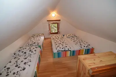 a attic room with two beds and a window at Apartment Cokla Rogla in Zreče