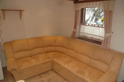 a brown couch in a living room with a window at Apartment Cokla Rogla in Zreče
