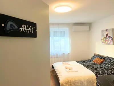 a bedroom with a bed and a sign on the wall at Ahat apartment in Maribor