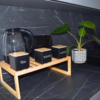 a table with three boxes and a tea kettle and a plant at Ahat apartment in Maribor