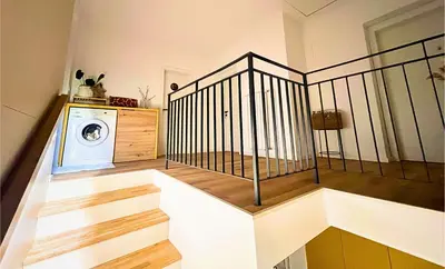 a room with a staircase with a washing machine at Ahat apartment in Maribor