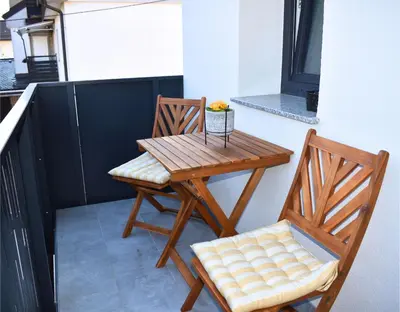 a wooden table and a chair on a balcony at Ahat apartment in Maribor
