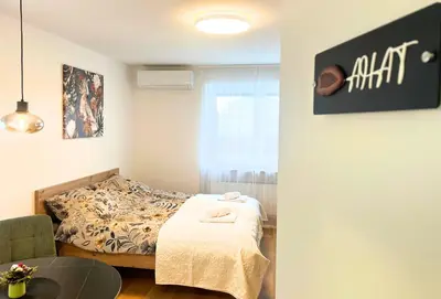 a small bedroom with a bed and a table at Ahat apartment in Maribor