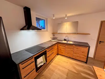 a kitchen with wooden cabinets and a counter top at Apartma Oblak in Kranjska Gora
