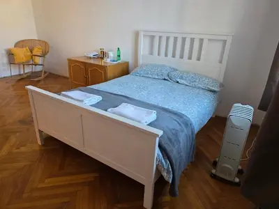a bedroom with a large white bed with blue sheets at Rooms in Maribor Centre in Maribor