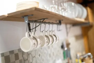 a bunch of coffee cups are hanging on a rack at Glamping Podgoro - Rogatec in Rogatec