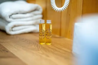 two bottles of honey sitting on a wooden table at Glamping Podgoro - Rogatec in Rogatec