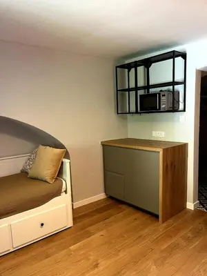 a bedroom with a bed and a microwave on the wall at Old town studio apartment in Ljubljana