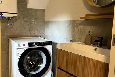a washing machine in a kitchen next to a sink at Old town studio apartment in Ljubljana