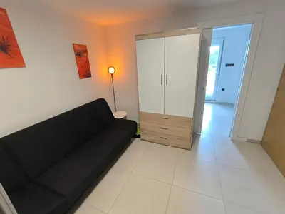 a living room with a black couch and a cabinet at Apartma JO-MA Mala Nedelja pri Bioterme in Mala Nedelja