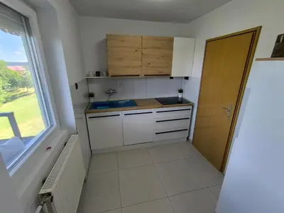 a small kitchen with white cabinets and a window at Apartma JO-MA Mala Nedelja pri Bioterme in Mala Nedelja