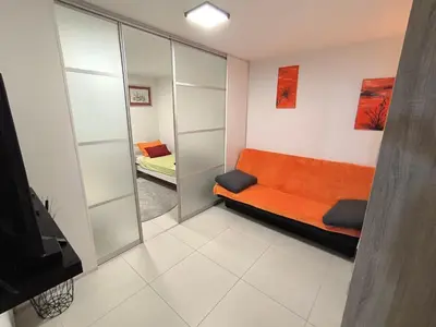 a small room with a couch and a mirror at Apartma JO-MA Mala Nedelja pri Bioterme in Mala Nedelja