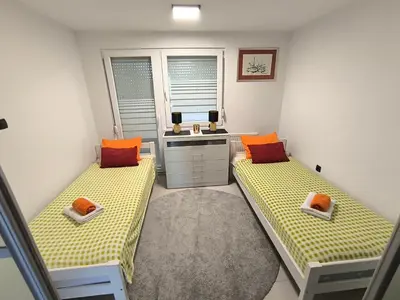 a room with two beds and a sink in it at Apartma JO-MA Mala Nedelja pri Bioterme in Mala Nedelja