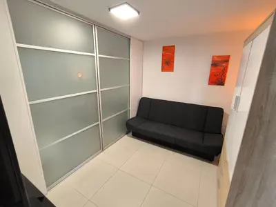 a living room with a black couch in a room at Apartma JO-MA Mala Nedelja pri Bioterme in Mala Nedelja