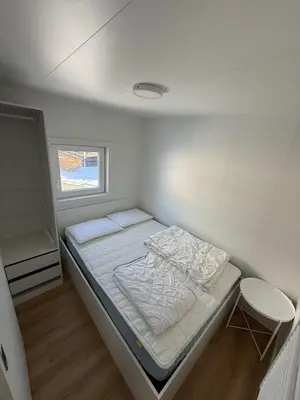 a small white room with a bed and a window at Hiška Moravska ravnica in Moravske Toplice