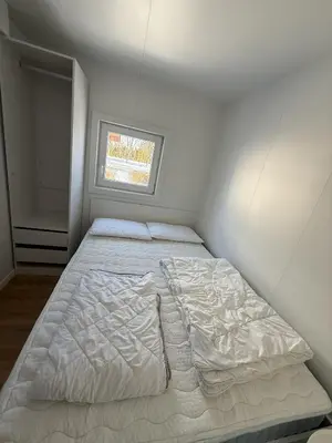 a bed in a white room with a window at Hiška Moravska ravnica in Moravske Toplice