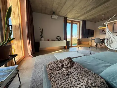a bedroom with a leopard print bed and a living room at Magda POP UP in Šentvid pri Stični