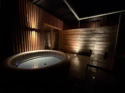 a bathroom with a large tub in a wooden wall at Magda POP UP in Šentvid pri Stični