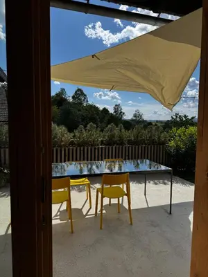 a table and two chairs under an umbrella on a patio at Magda POP UP in Šentvid pri Stični