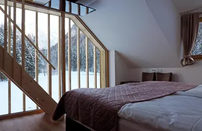 a bedroom with a bed and a large window at Gostišče Jezersko in Zgornje Jezersko