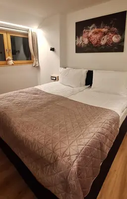 a bedroom with a large bed in a room at Gostišče Jezersko in Zgornje Jezersko