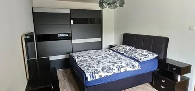 a small bedroom with a bed with a black headboard at Apartment Milan in Zreče