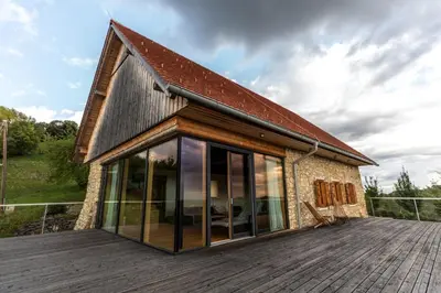 a house with glass doors on a wooden deck at Vila Podigrac in Zgornja Kungota