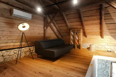 a living room with a chair and a lamp at Vila Podigrac in Zgornja Kungota