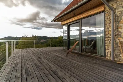 a wooden deck with glass doors on a house at Vila Podigrac in Zgornja Kungota
