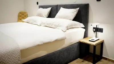 a bedroom with two beds and a side table at Turistična kmetija in pivovarna Flajs in Žalec