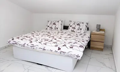a bedroom with a bed with a floral bedspread at Gostišče cimi in Kozina