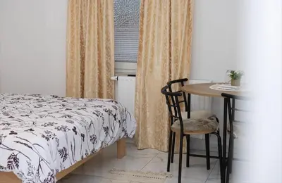 a bedroom with a bed and a table with a chair at Gostišče cimi in Kozina