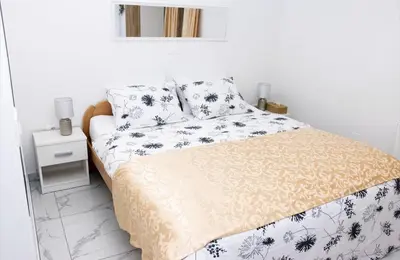 a bedroom with a bed with a yellow and white comforter at Gostišče cimi in Kozina
