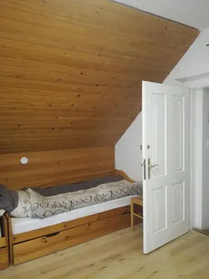 a bed in a room with a wooden ceiling at vintage paradise near Kranjska Gora in Mojstrana