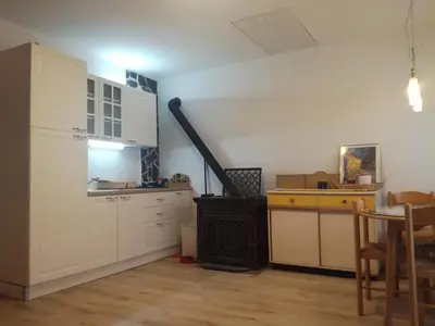 a kitchen with white cabinets and a sink and a table at vintage paradise near Kranjska Gora in Mojstrana