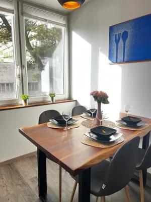 a dining room with a wooden table and chairs at D&D Sunny Ljubljana apartment in Vič