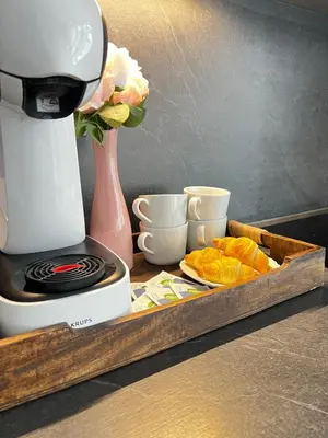 a cutting board with a coffee maker and a tray of bread at D&D Sunny Ljubljana apartment in Vič