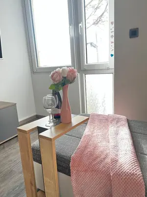 a living room with a vase of flowers on a table at D&D Sunny Ljubljana apartment in Vič