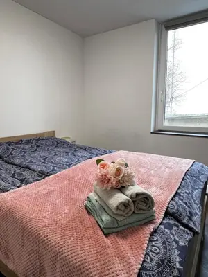 a bedroom with a bed with towels and a window at D&D Sunny Ljubljana apartment in Vič