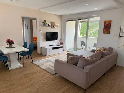 a living room with a couch and a table at Two bedrom Modern Flat near Ljubljana Private Garage &Balcony in Dobrova