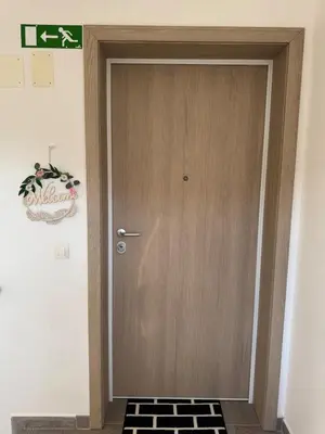 a wooden door in a room with a tile floor at Two bedrom Modern Flat near Ljubljana Private Garage &Balcony in Dobrova