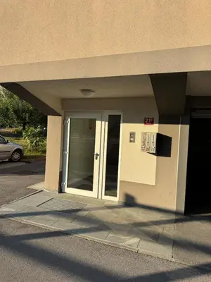 an entrance to a building with a glass door at Two bedrom Modern Flat near Ljubljana Private Garage &Balcony in Dobrova