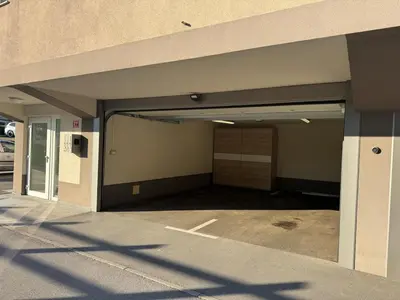 an empty parking garage with an open garage door at Two bedrom Modern Flat near Ljubljana Private Garage &Balcony in Dobrova