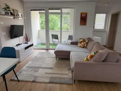 a living room with a couch and a tv at Two bedrom Modern Flat near Ljubljana Private Garage &Balcony in Dobrova
