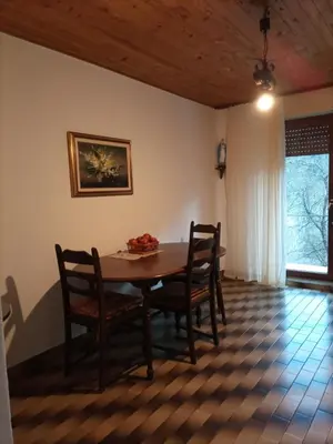 a dining room table and chairs in a room at Apartma pri Ivanu in Spodnja Idrija