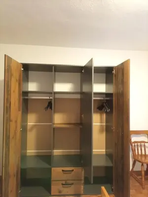 a closet with glass shelves and a wooden door at Apartma pri Ivanu in Spodnja Idrija