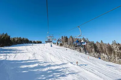 a group of people on a ski lift in the snow at APARTMENTS ROGLA LUKANJA 1 in Oplotnica