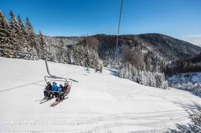 a group of people on a ski lift in the snow at APARTMENTS ROGLA LUKANJA 1 in Oplotnica