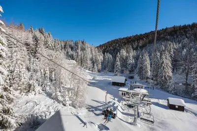 a group of people on a ski lift in the snow at APARTMENTS ROGLA LUKANJA 1 in Oplotnica